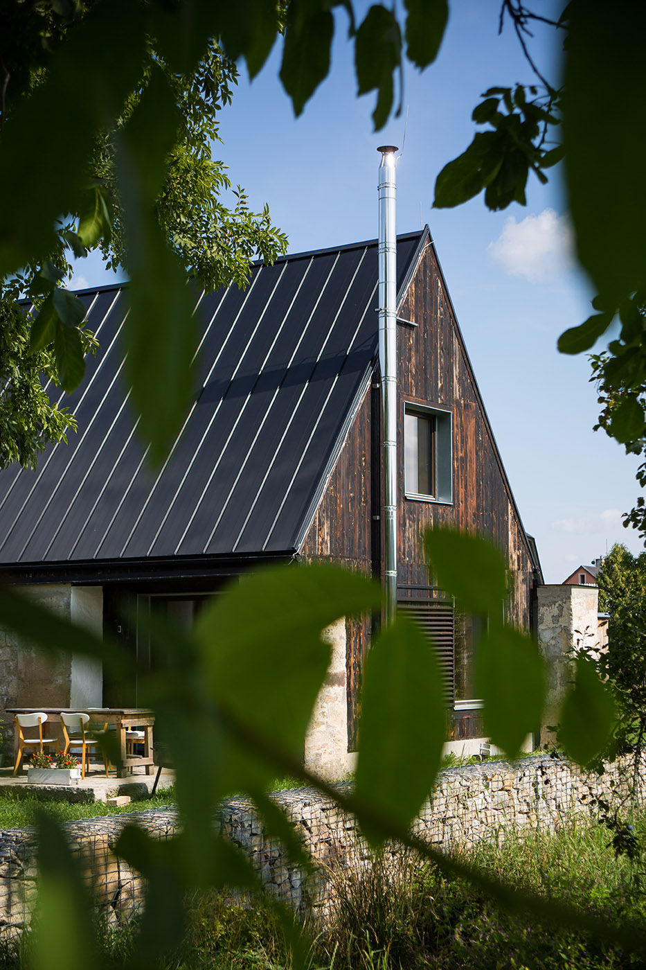 The old barn gives way to a small wooden house. Monumental granite walls preserved