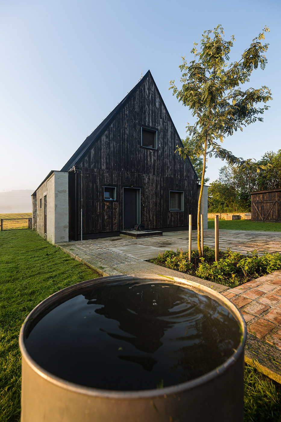 The old barn gives way to a small wooden house. Monumental granite walls preserved