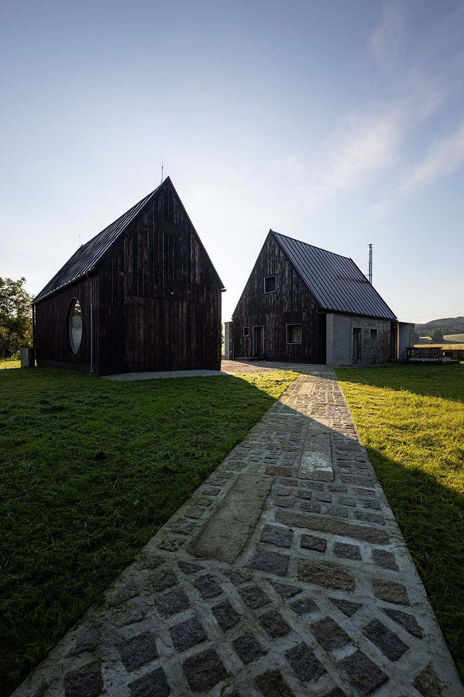 The old barn gives way to a small wooden house. Monumental granite walls preserved