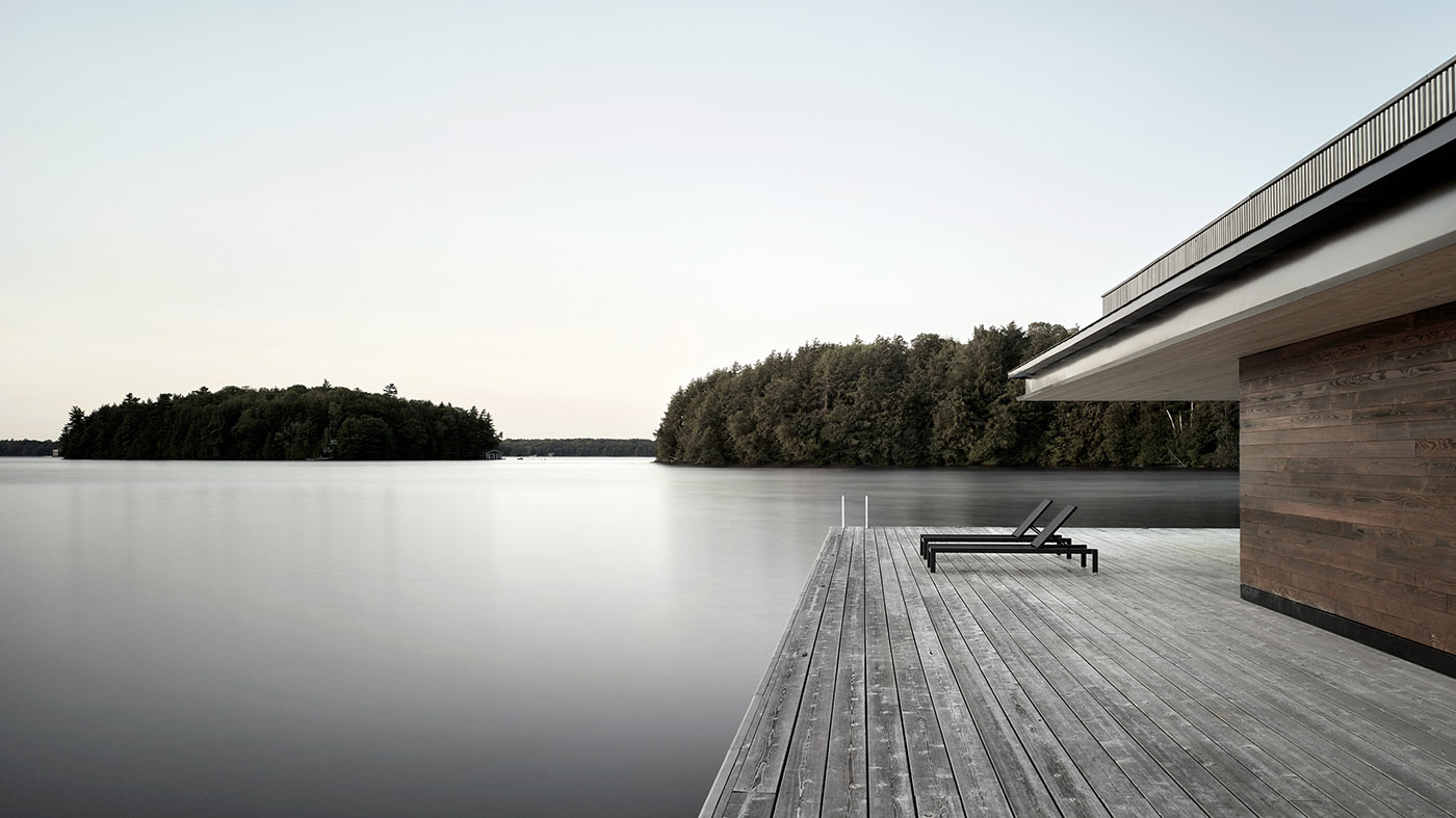 A rocky enclave houses a wooden cottage. Boathouse on the shores of a lake