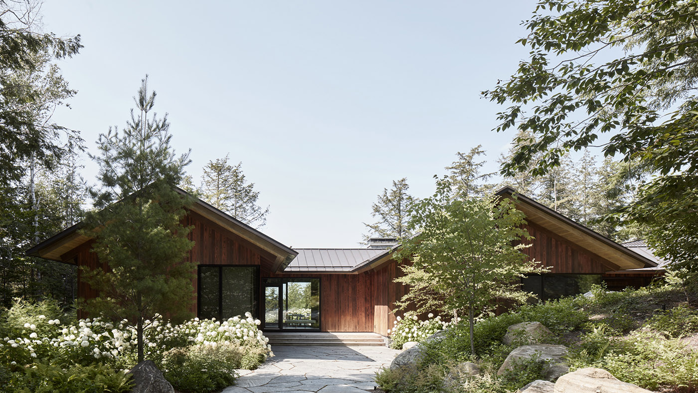 A rocky enclave houses a wooden cottage. Boathouse on the shores of a lake