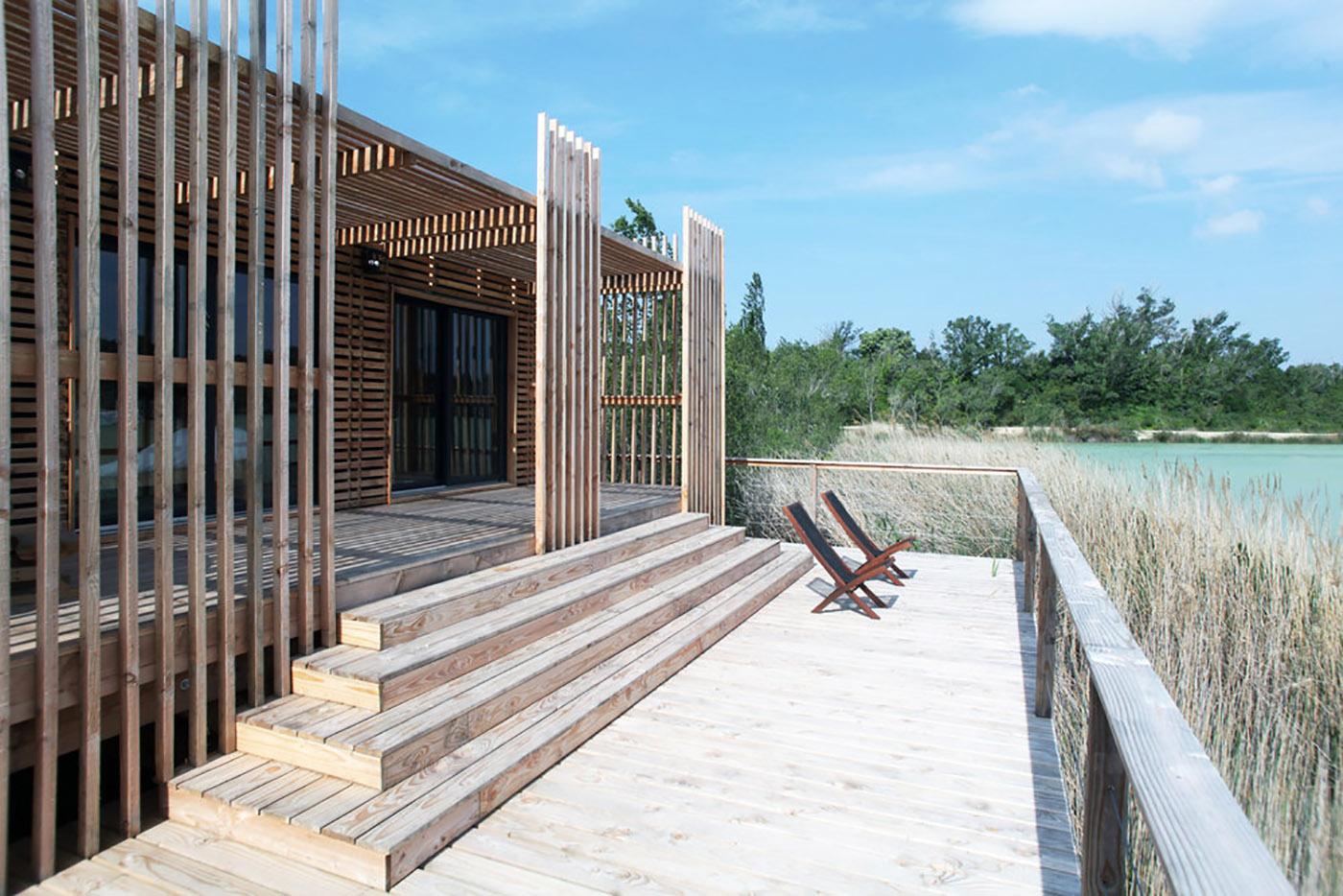 Wooden suites at the Grand Cepage Hotel, resembling the sophisticated nests among the reeds, are reflected in the lake for a primordial living experience
