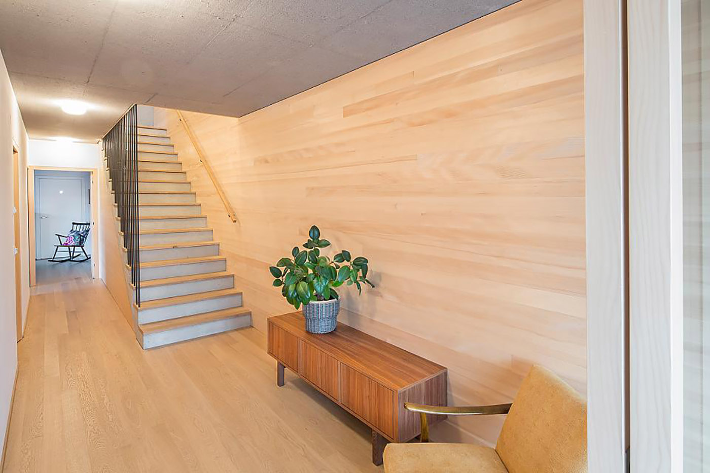 Haus Moosbrugger: a home standing on a steep slope, a wooden shell projected onto the Swiss landscape