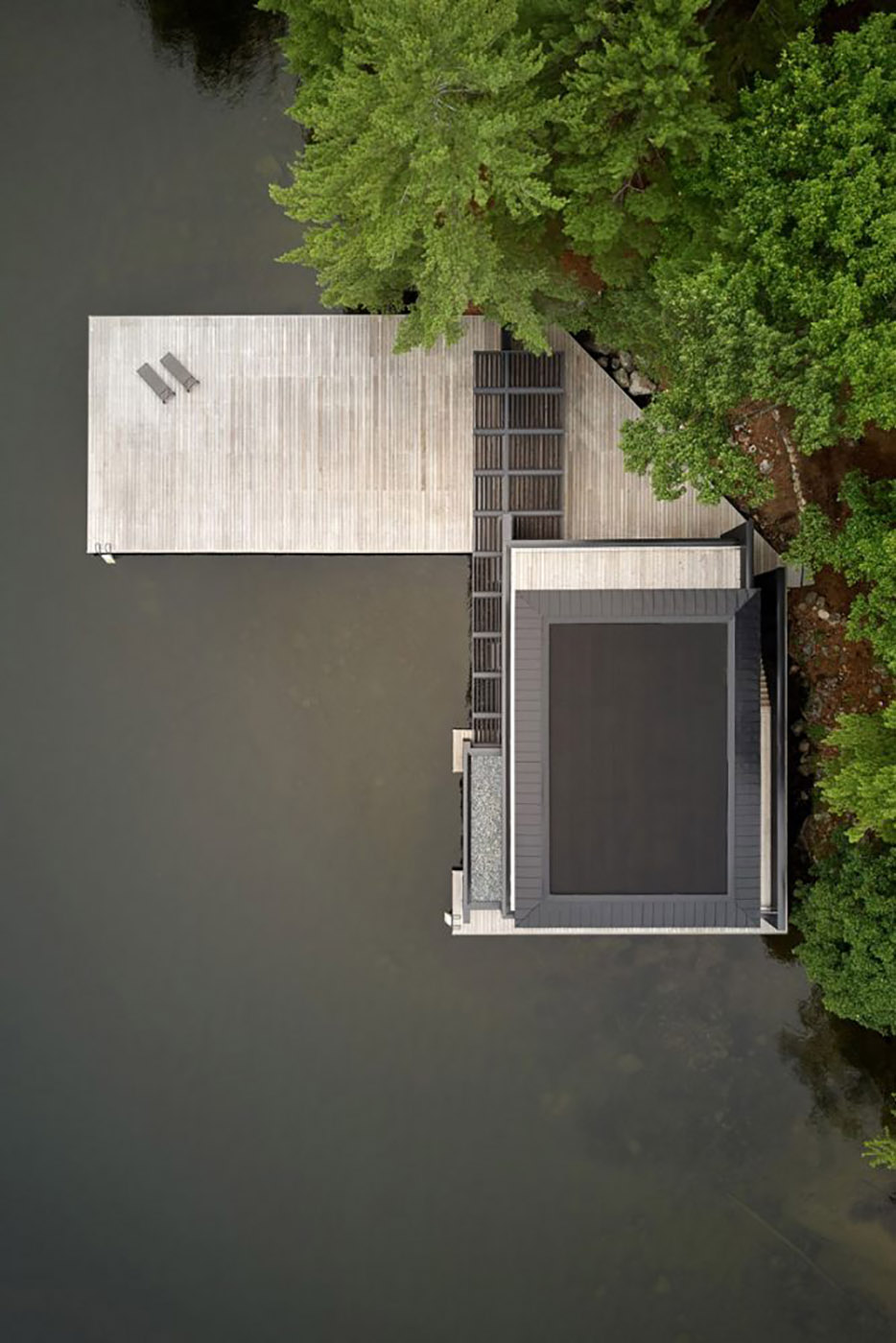 Charred Wood Boathouse. Parallel wooden planes build an ethereal space on the lakeshore