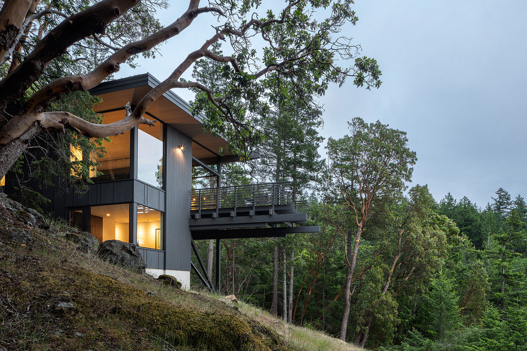 A dwelling that anchors itself to an existing rock in Buck Mountain Cabin