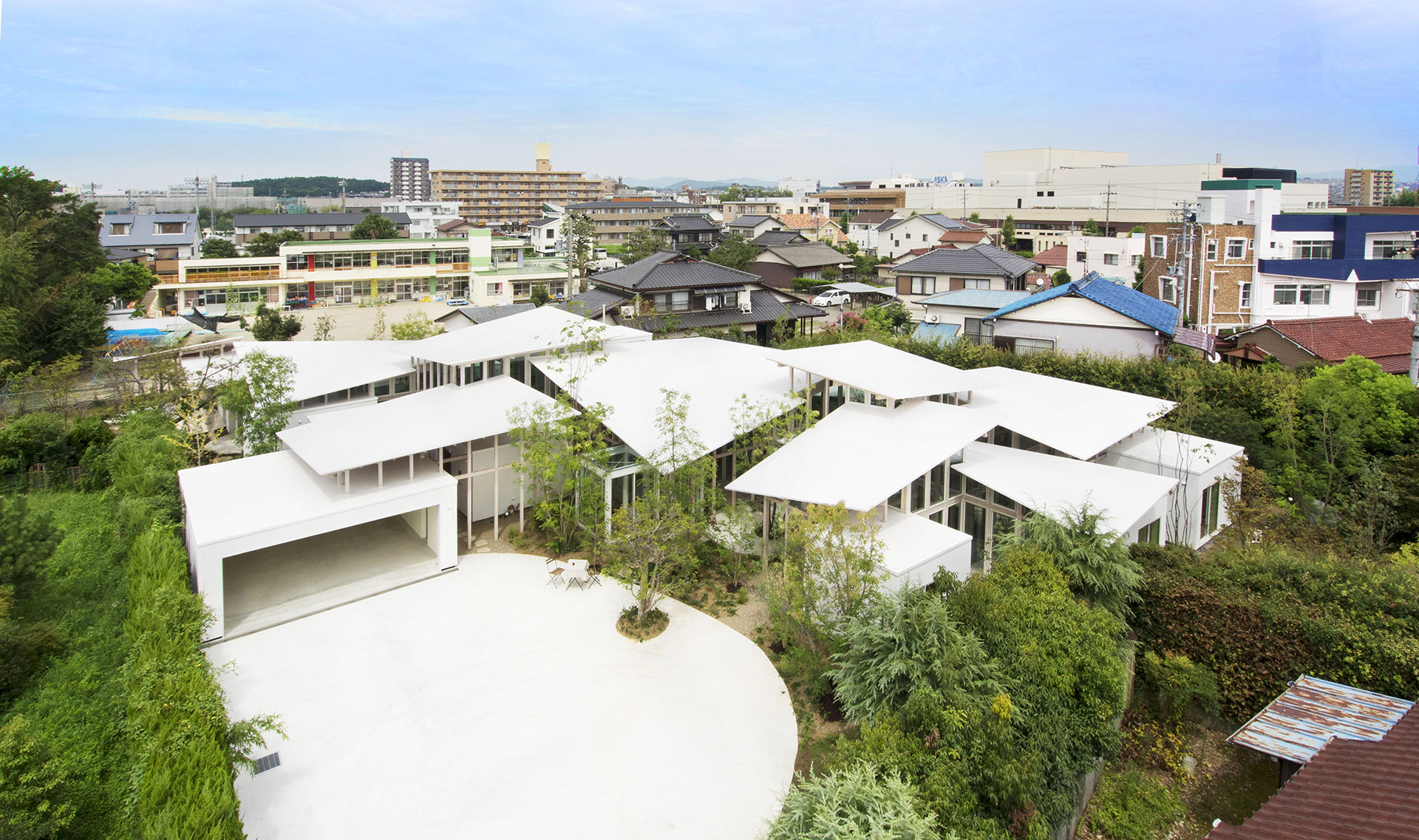 See-through living space that's protected by vegetation. A dynamically shaped house in Japan