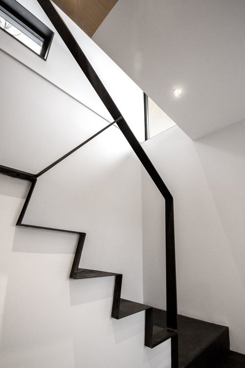 Internal staircase with black treads and black balustrade