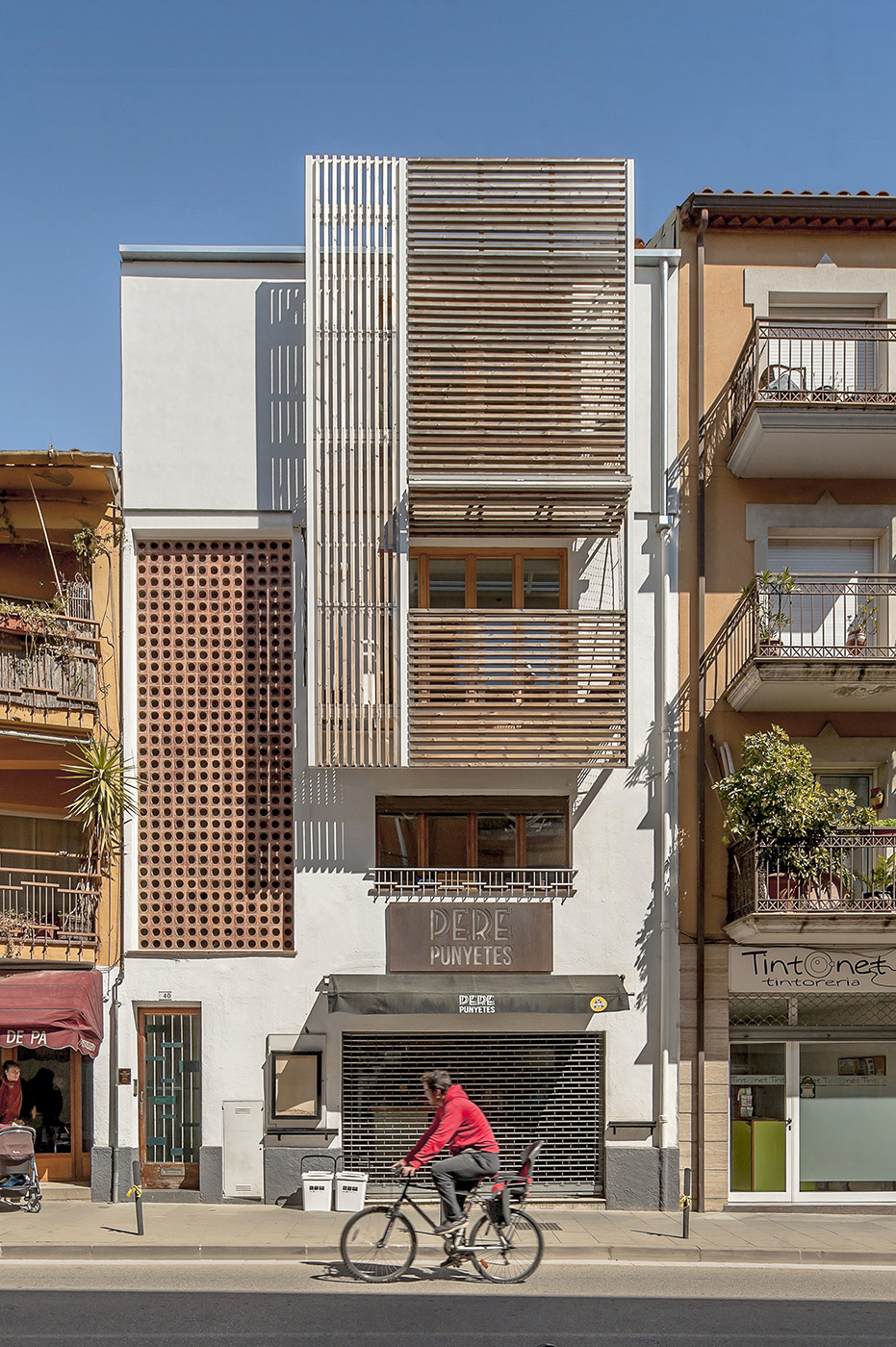 Renovation of a building in Catalonia. Wooden staves reinterpret the facade