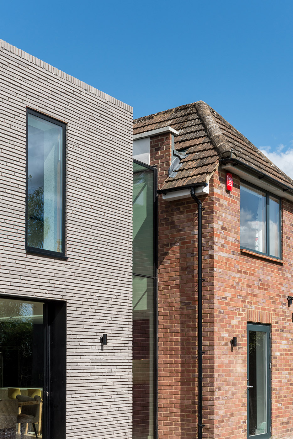 Long Brick House. Une boîte de briques en pierre reliée à la structure préexistante par un couloir vitré