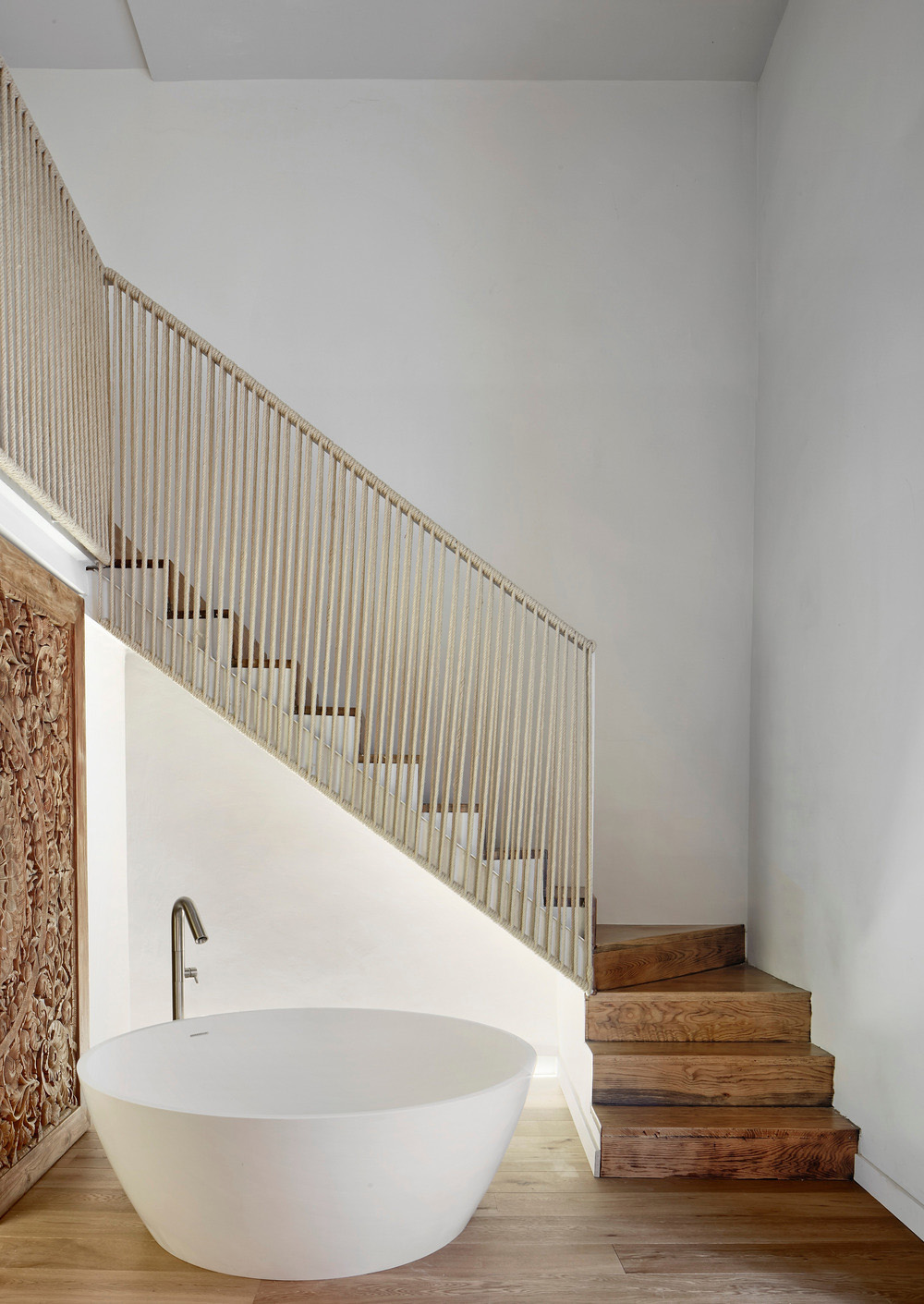 staircase of a loft with rope balustrade and circular tub