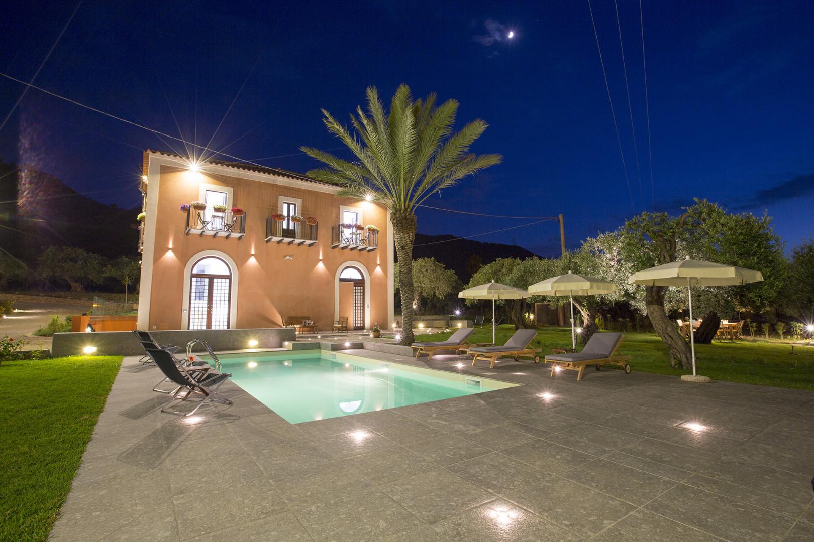 Casa con piscina di notte illuminata