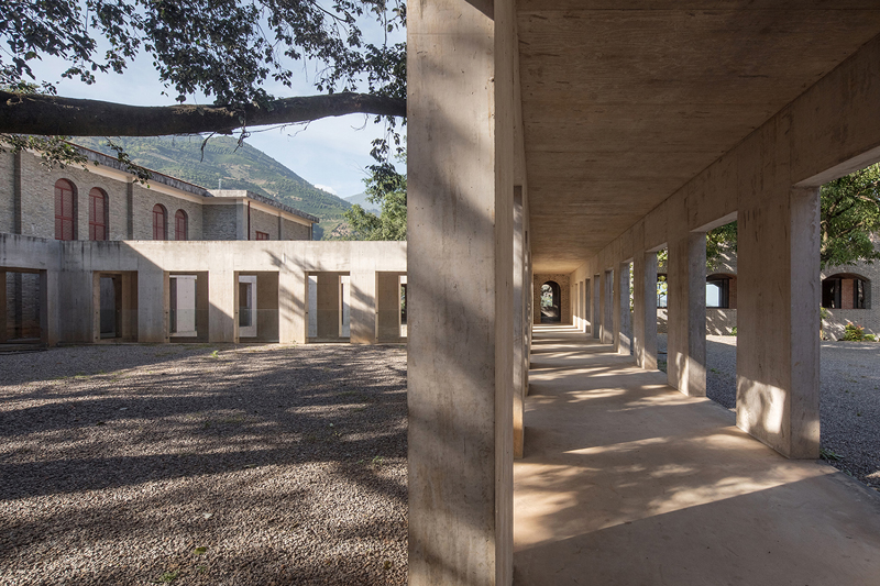 Briques, cours, arbres luxuriants. Rénovation d'un bâtiment datant des années 80