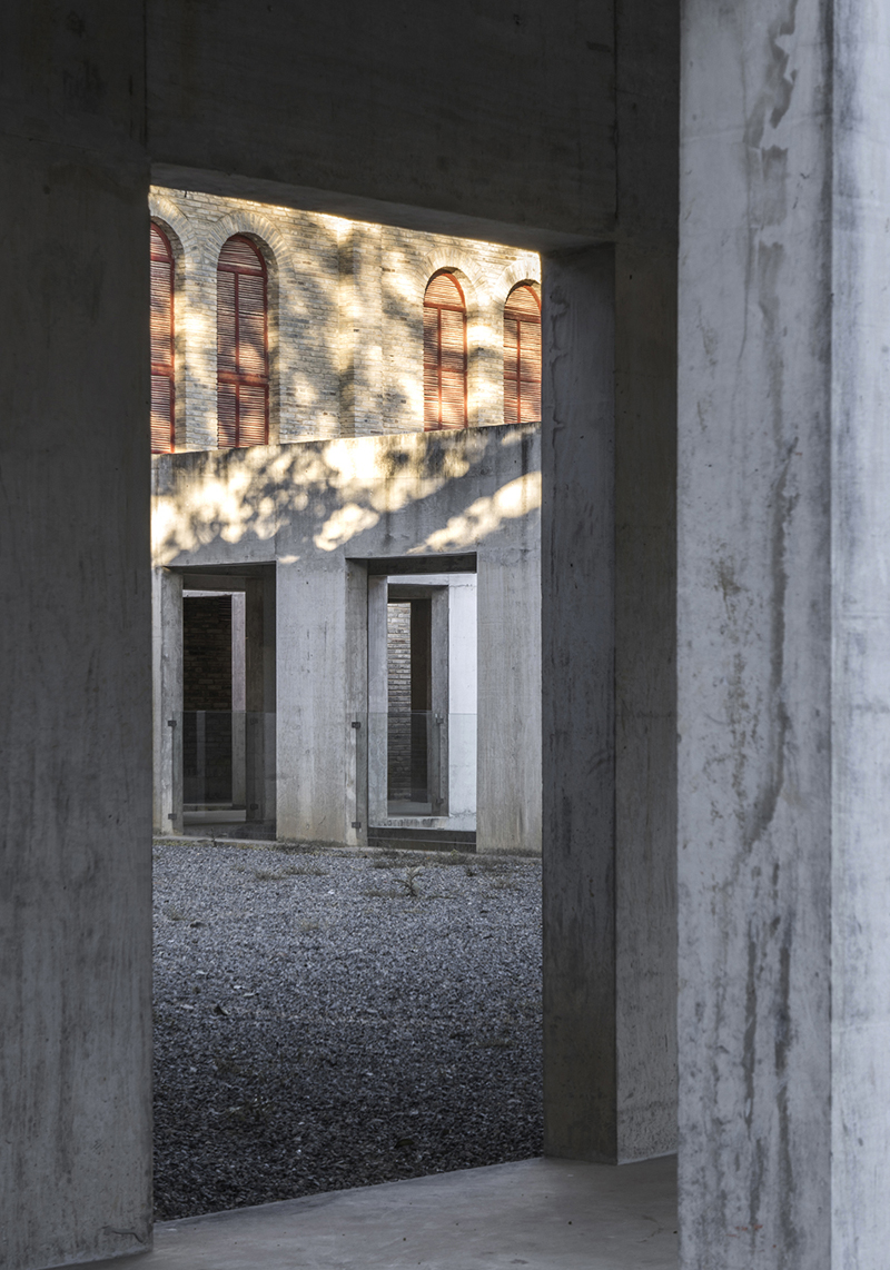 Briques, cours, arbres luxuriants. Rénovation d'un bâtiment datant des années 80