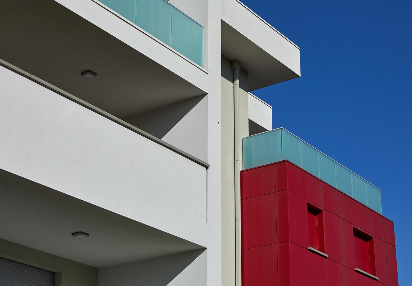 Complesso residenziale a Brescia. Volumi architettonici puri enfatizzati dal colore e dall’essenzialità del vetro