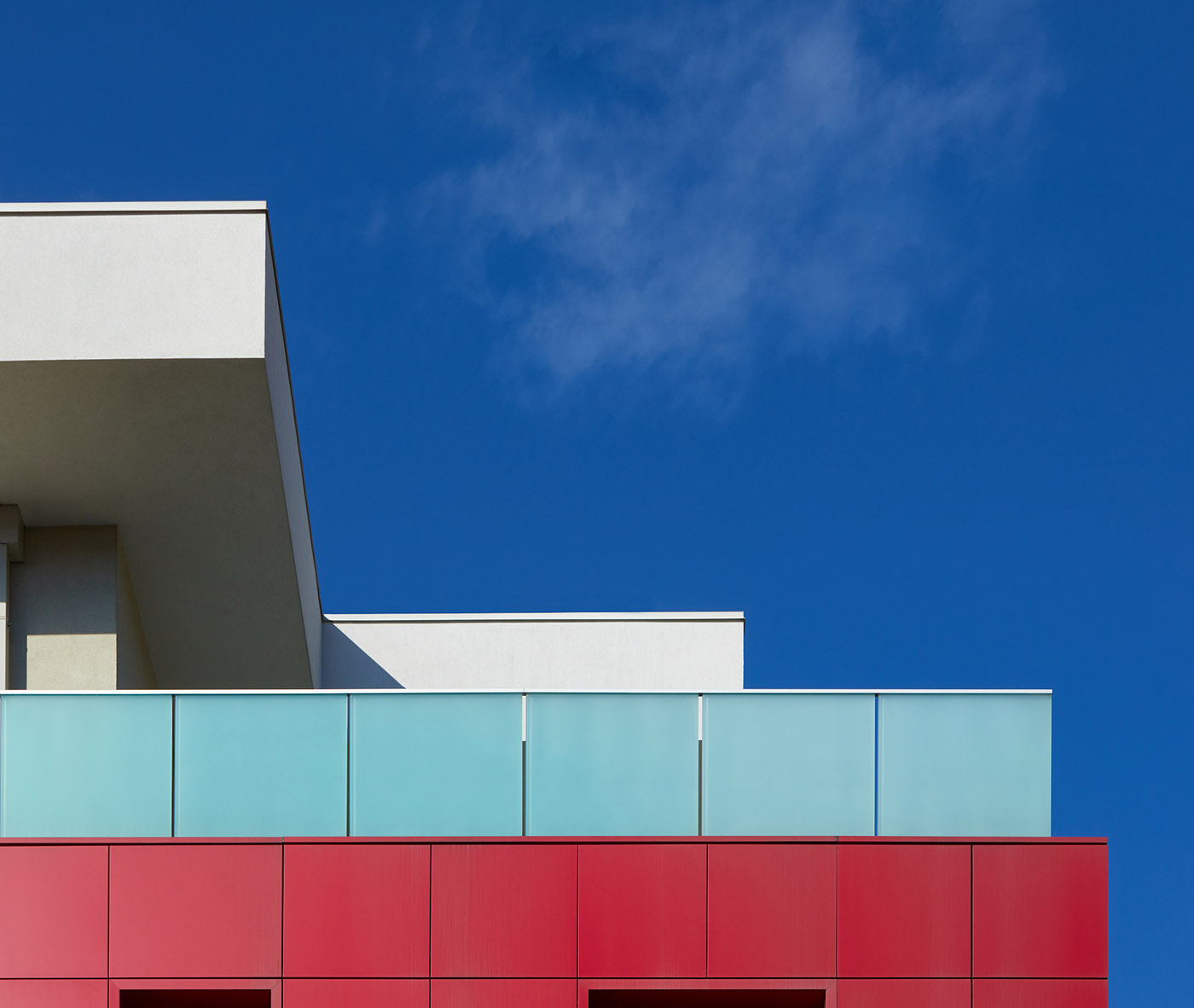 Complesso residenziale a Brescia. Volumi architettonici puri enfatizzati dal colore e dall’essenzialità del vetro