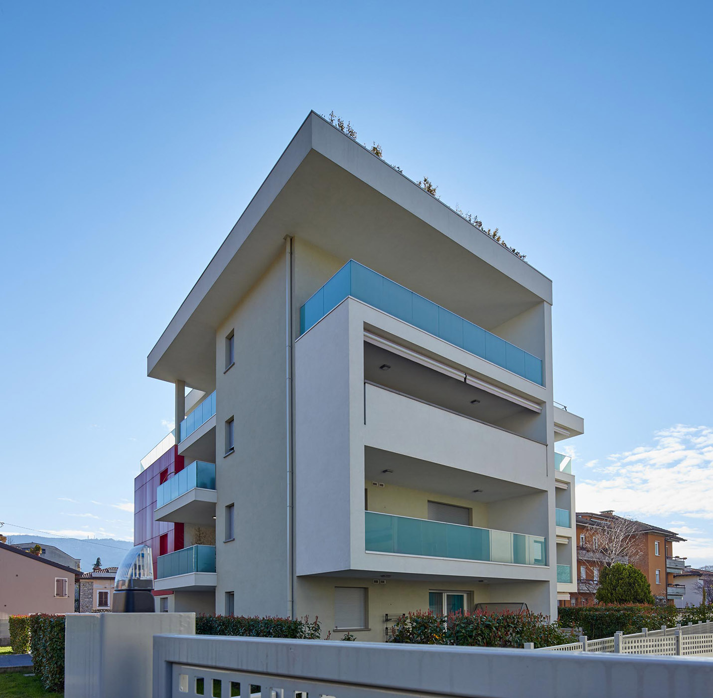 Complesso residenziale a Brescia. Volumi architettonici puri enfatizzati dal colore e dall’essenzialità del vetro