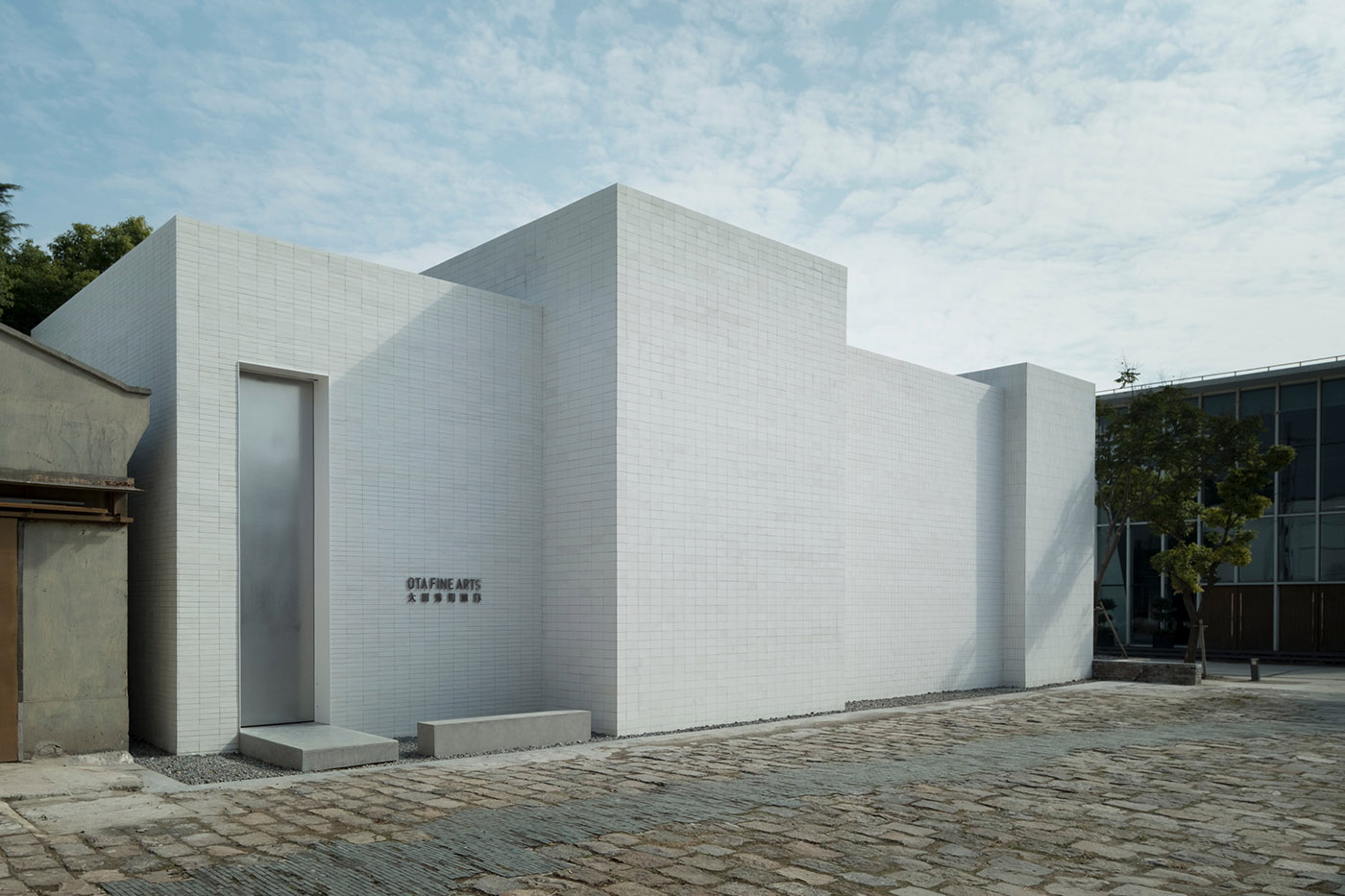 Purity of volume, natural light and traditional materials blend in the design of the new OTA FINE ARTS gallery