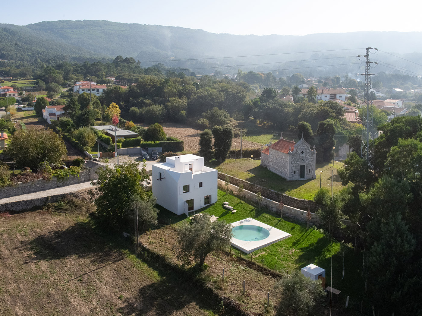 Casa em Afife. Minimalist architecture designed to blend in with the natural slopes of the land