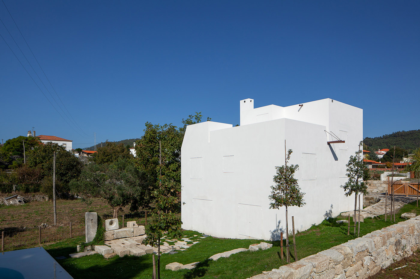 Casa em Afife. Minimalist architecture designed to blend in with the natural slopes of the land