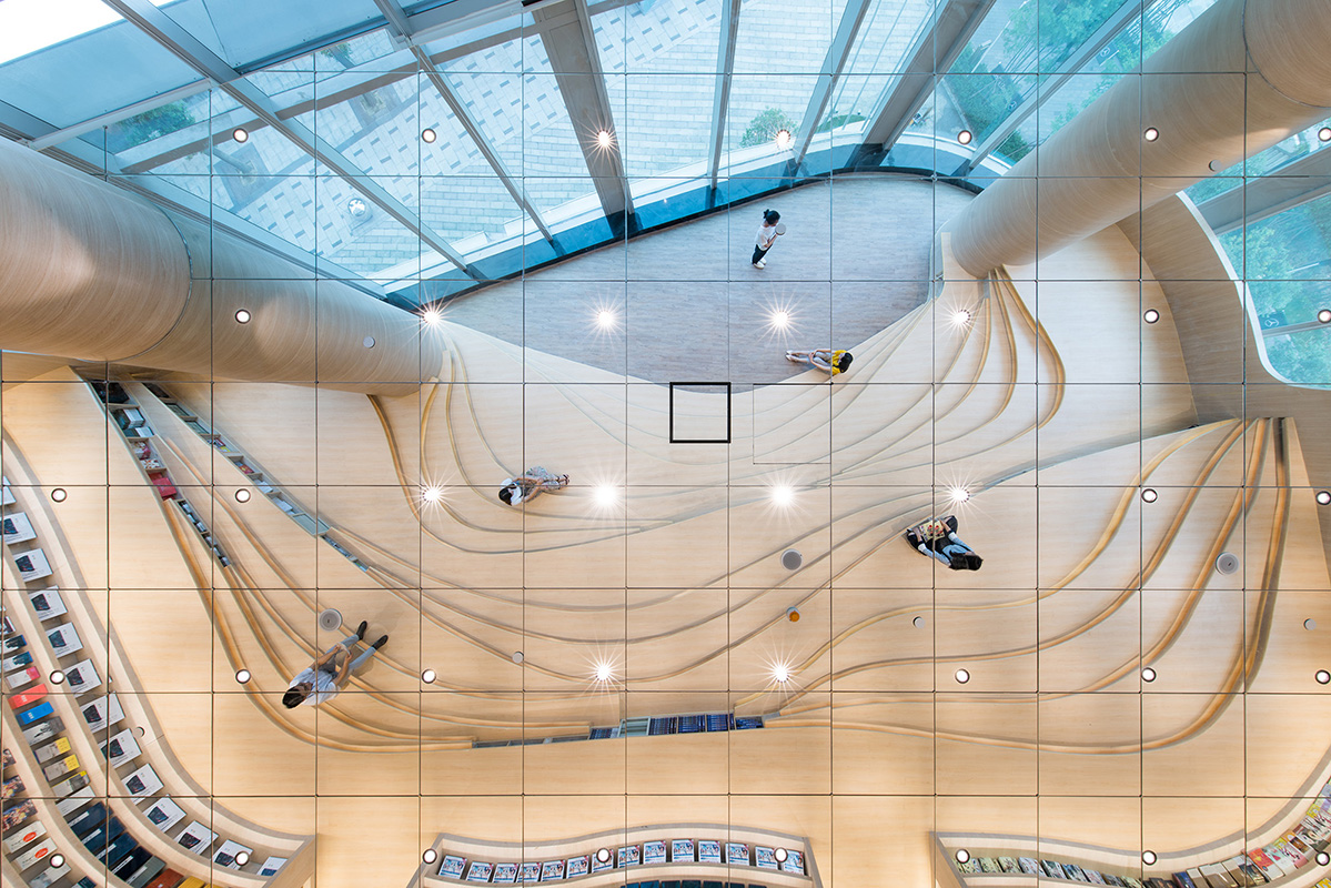 The bookcase and the large curved glass window