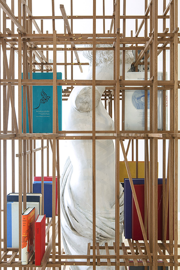 The bookcase envelops the work of art