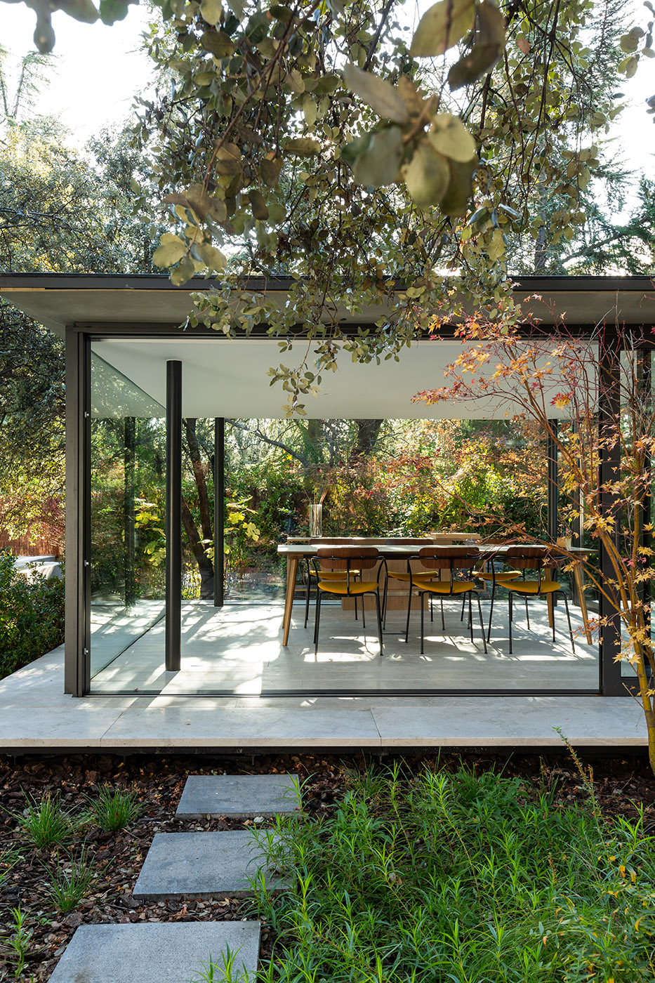 interior glazed pavilion with ochre table and chairs