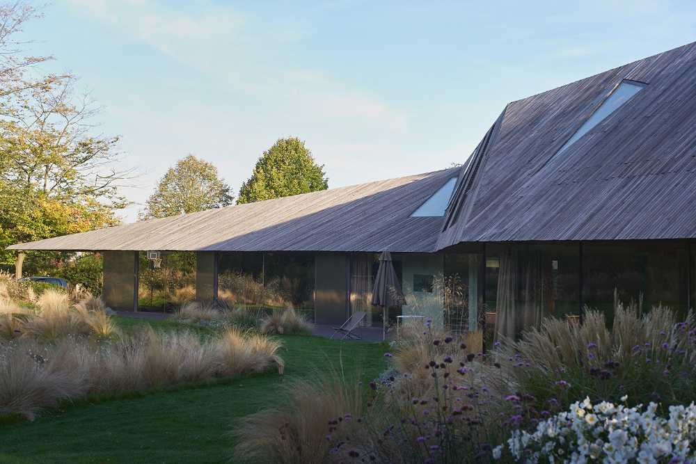 House nestled on the edge of a forest. The elegance of materials and forms gives harmony to the structure