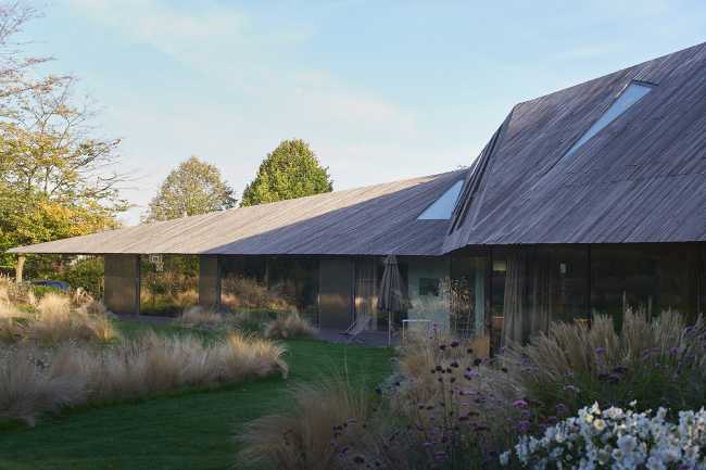House nestled on the edge of a forest. The elegance of materials and forms gives harmony to the structure