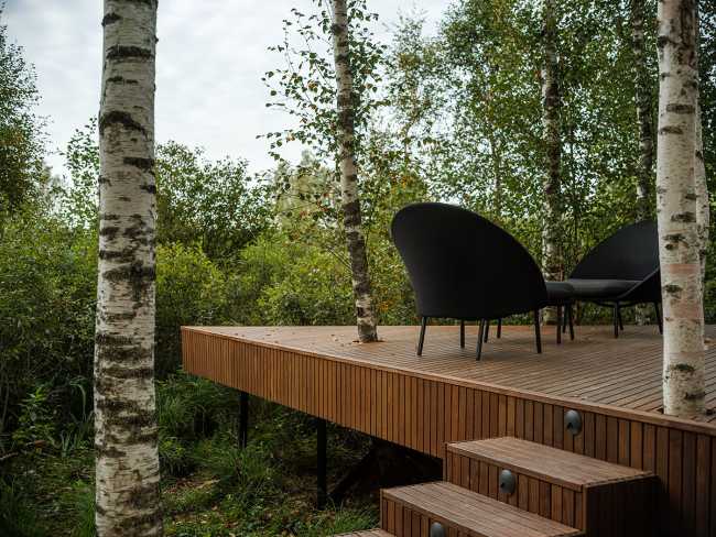 Petit hôtel en bordure d'un marais. Des bouleaux entourent la chambre d'hôtel