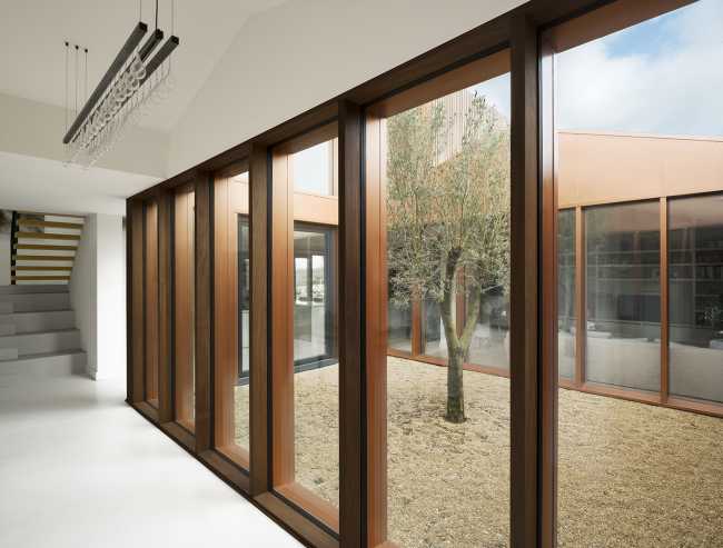 Juego de volúmenes tradicionales de un granero. Formas y paleta de materiales locales