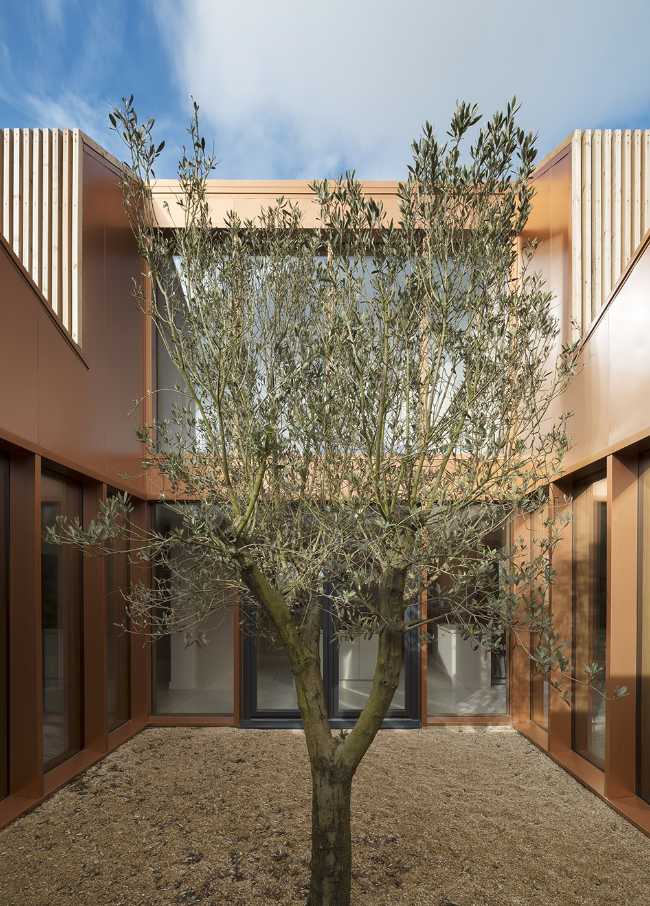 Juego de volúmenes tradicionales de un granero. Formas y paleta de materiales locales