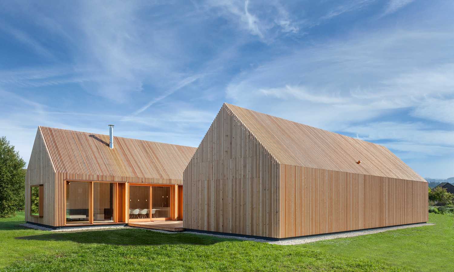Minimal design for a wooden house. Harmony between the larch wood exterior and the landscape