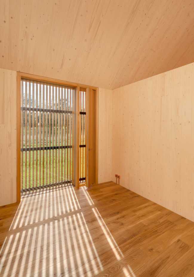 Minimal design for a wooden house. Harmony between the larch wood exterior and the landscape