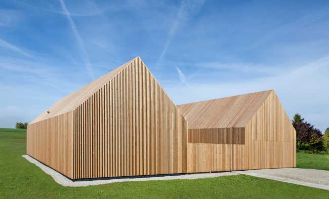 Minimal design for a wooden house. Harmony between the larch wood exterior and the landscape