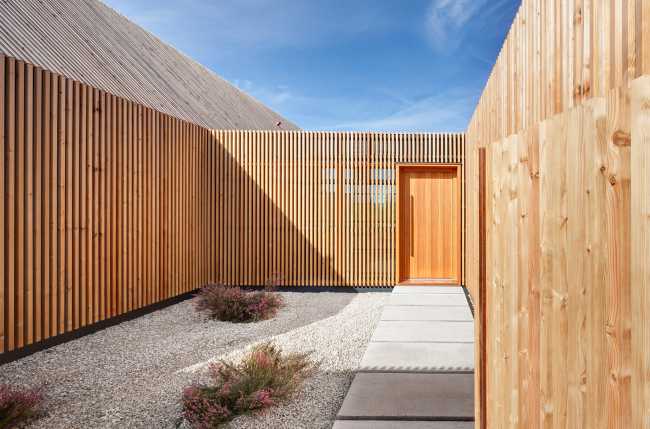 Minimal design for a wooden house. Harmony between the larch wood exterior and the landscape