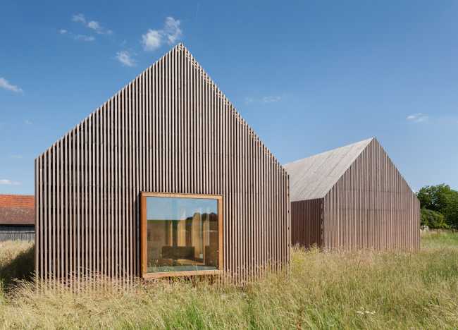 Minimal design for a wooden house. Harmony between the larch wood exterior and the landscape