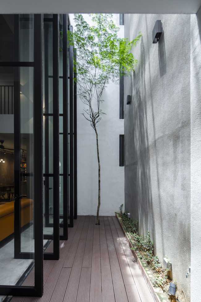 Outdoor che irrompe nell’indoor. Luce, cielo, aria e vegetazione vivificano una casa industrial-chic