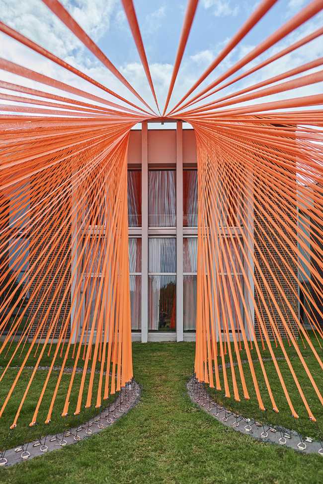 A pavilion of orange threads. United but separate to reflect on the historical moment we are living in