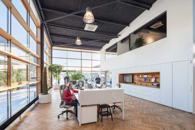 Magazzino trasformato in un ufficio. Lo spazio di lavoro viene innondato di luce naturale
