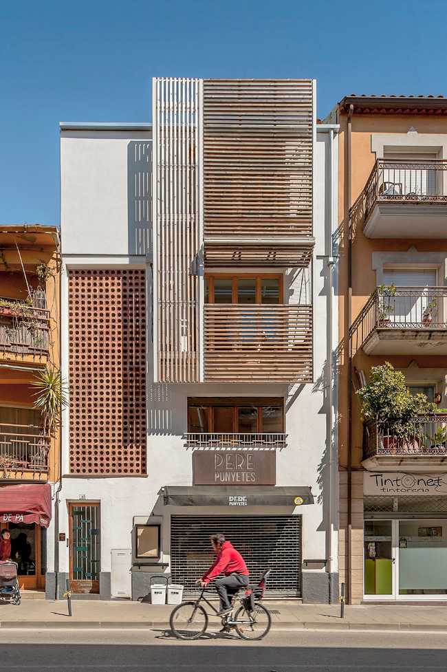 Riqualificazione di un edificio in Catalogna. Le doghe in legno reinterpretano la facciataRiqualificazione di un edificio in Catalogna. Le doghe in legno reinterpretano la facciata