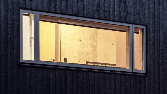 Wooden dwelling with dark tones. Glossy surfaces ranging from deep black to silver and bluish tones