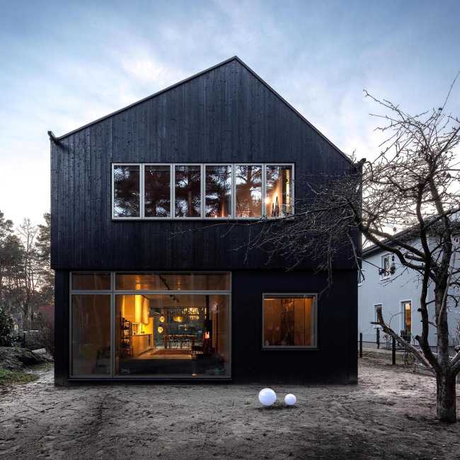 Wooden dwelling with dark tones. Glossy surfaces ranging from deep black to silver and bluish tones