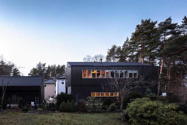 Wooden dwelling with dark tones. Glossy surfaces ranging from deep black to silver and bluish tones