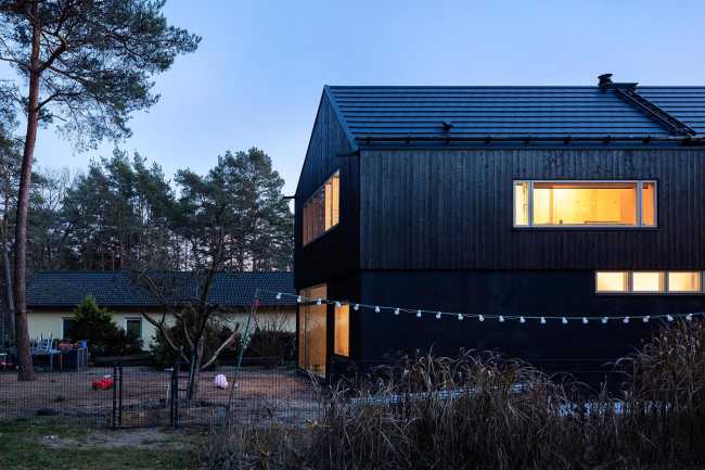 Wooden dwelling with dark tones. Glossy surfaces ranging from deep black to silver and bluish tones