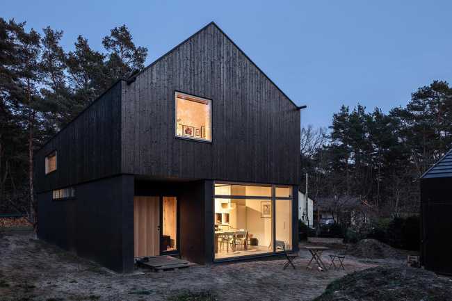 Wooden dwelling with dark tones. Glossy surfaces ranging from deep black to silver and bluish tones