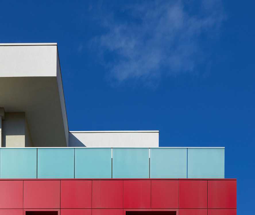 Complesso residenziale a Brescia. Volumi architettonici puri enfatizzati dal colore e dall’essenzialità del vetro