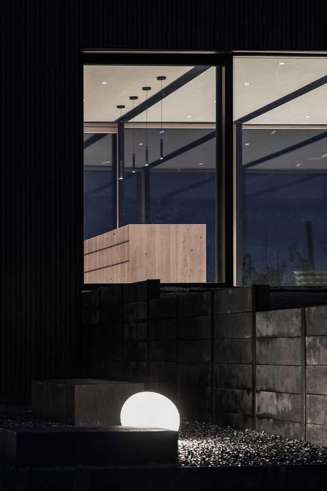 House on wine terraces. Wooden slats cover the structure like a velvety black veil