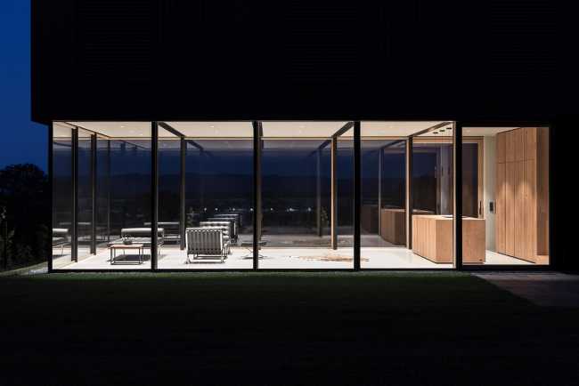 House on wine terraces. Wooden slats cover the structure like a velvety black veil
