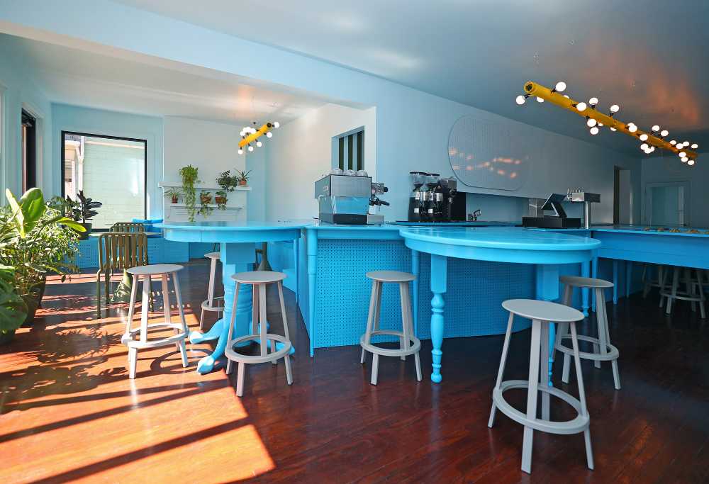 Típico café neoyorquino. Mesas recicladas forman un mostrador azul que maximiza las interacciones sociales