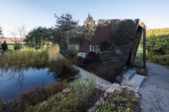 Floating Sculpted Space. The bronze colored facade elegantly reflects the environment
